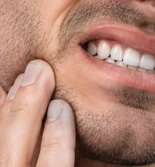 Hombre con dolor en la mandíbula, apretando los dientes